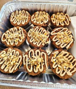 vegan spice muffins topped with brown sugar frosting and chopped nuts